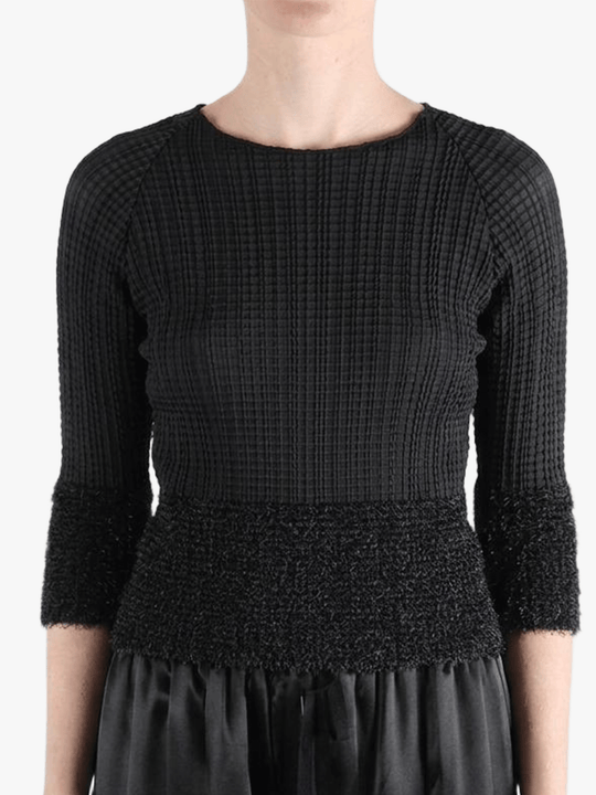 Black knitwear worn by a person,showing the knitwear fit