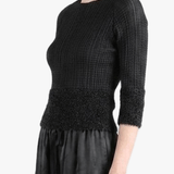 Black knitwear worn by a person,showing the knitwear fit