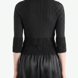 Black knitwear worn by a person,showing the knitwear fit