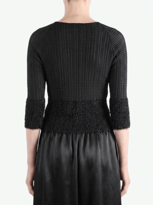 Black knitwear worn by a person,showing the knitwear fit