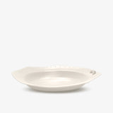 JINJIN PARIS Croissant Octagon Plate in ivory porcelain, side view with sculpted croissant detail and dotted rim.