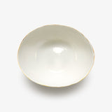 Top view of JINJIN PARIS Golden Rim Bowl Large in glazed ivory porcelain with asymmetrical circular shape and gold edging.