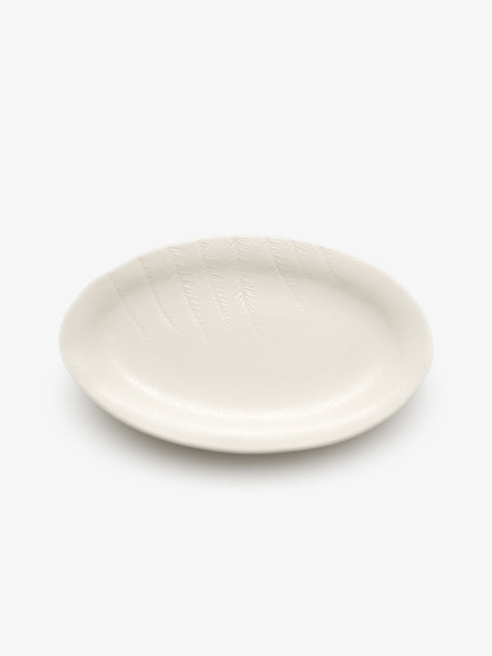 JINJIN PARIS Leaf Oval Plate in ivory porcelain, angled top view showing oval silhouette and botanical detailing.