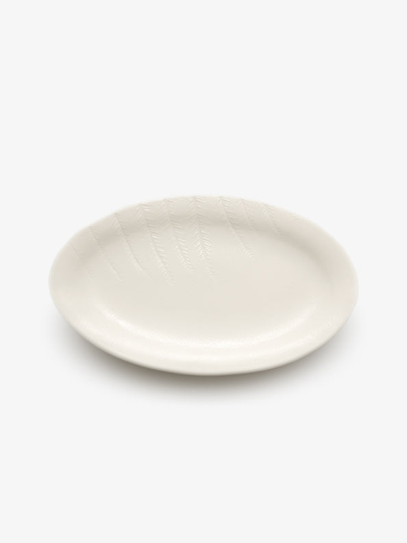 JINJIN PARIS Leaf Oval Plate in ivory porcelain, angled top view showing oval silhouette and botanical detailing.