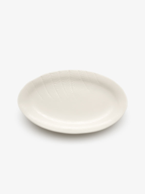 JINJIN PARIS Leaf Oval Plate in ivory porcelain, angled top view showing oval silhouette and botanical detailing.