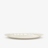 JINJIN PARIS Leaf Oval Plate in ivory porcelain, side view with shallow profile and embossed leaf texture.