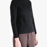 Black knitwear worn by a person, showing the knitwear fit