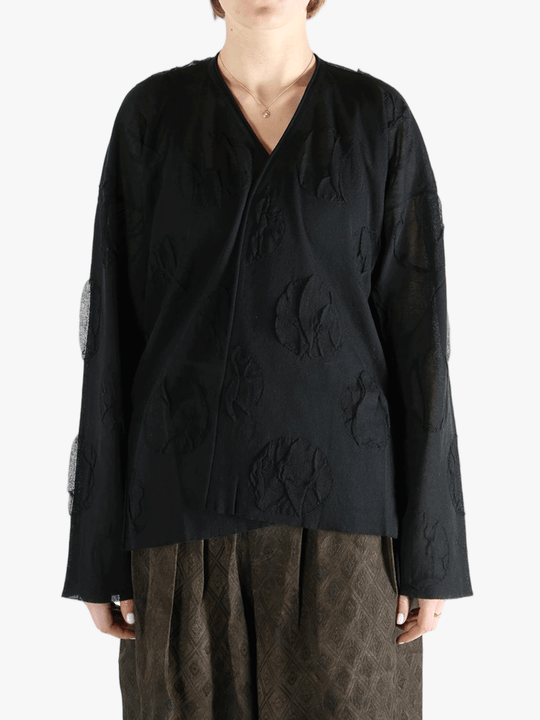 Black cardigan worn by a person, showing the cardigan fit