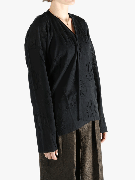 Black cardigan worn by a person, showing the cardigan fit