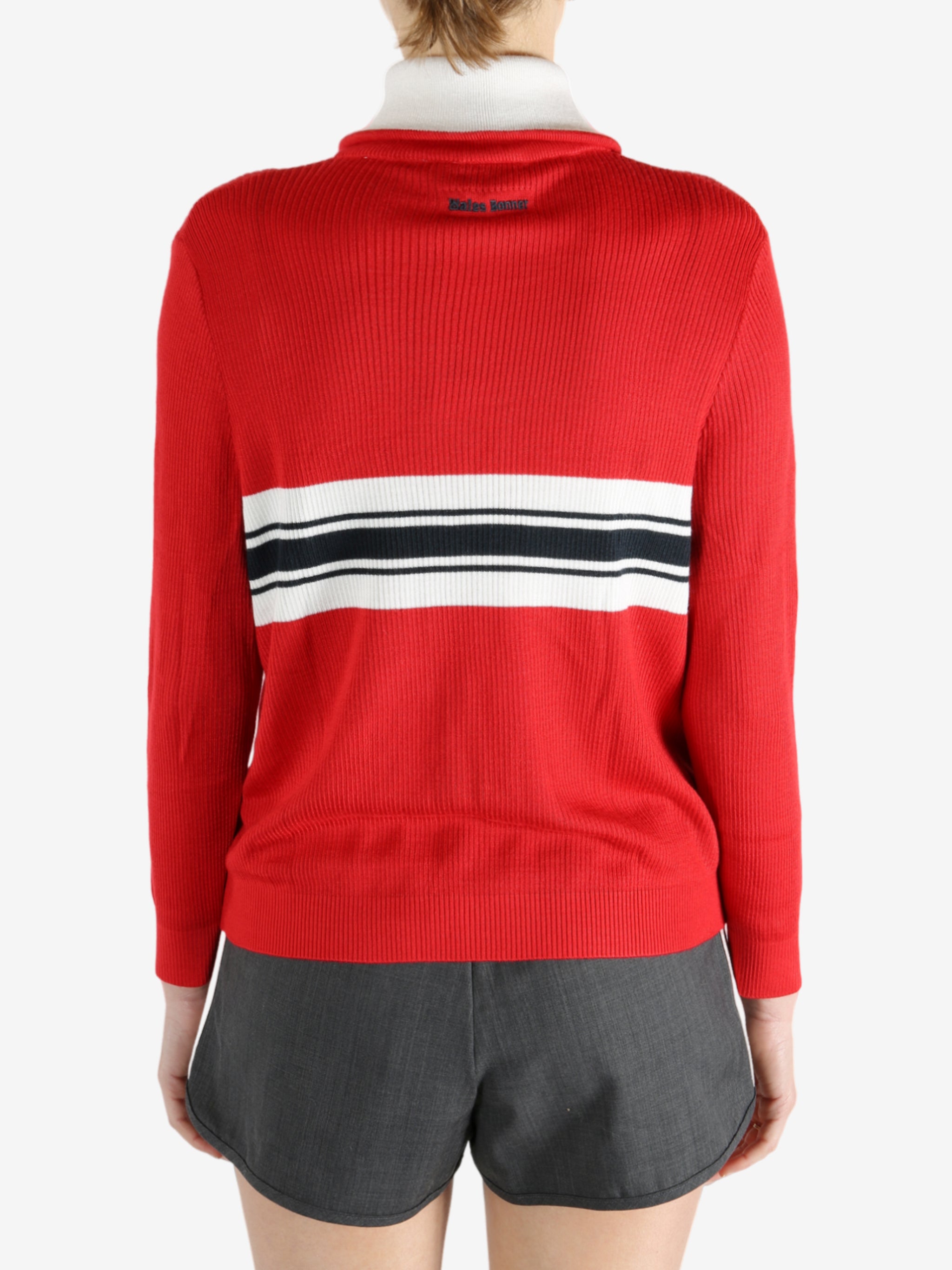 Red knitwear worn by a person, showing the knitwear fit