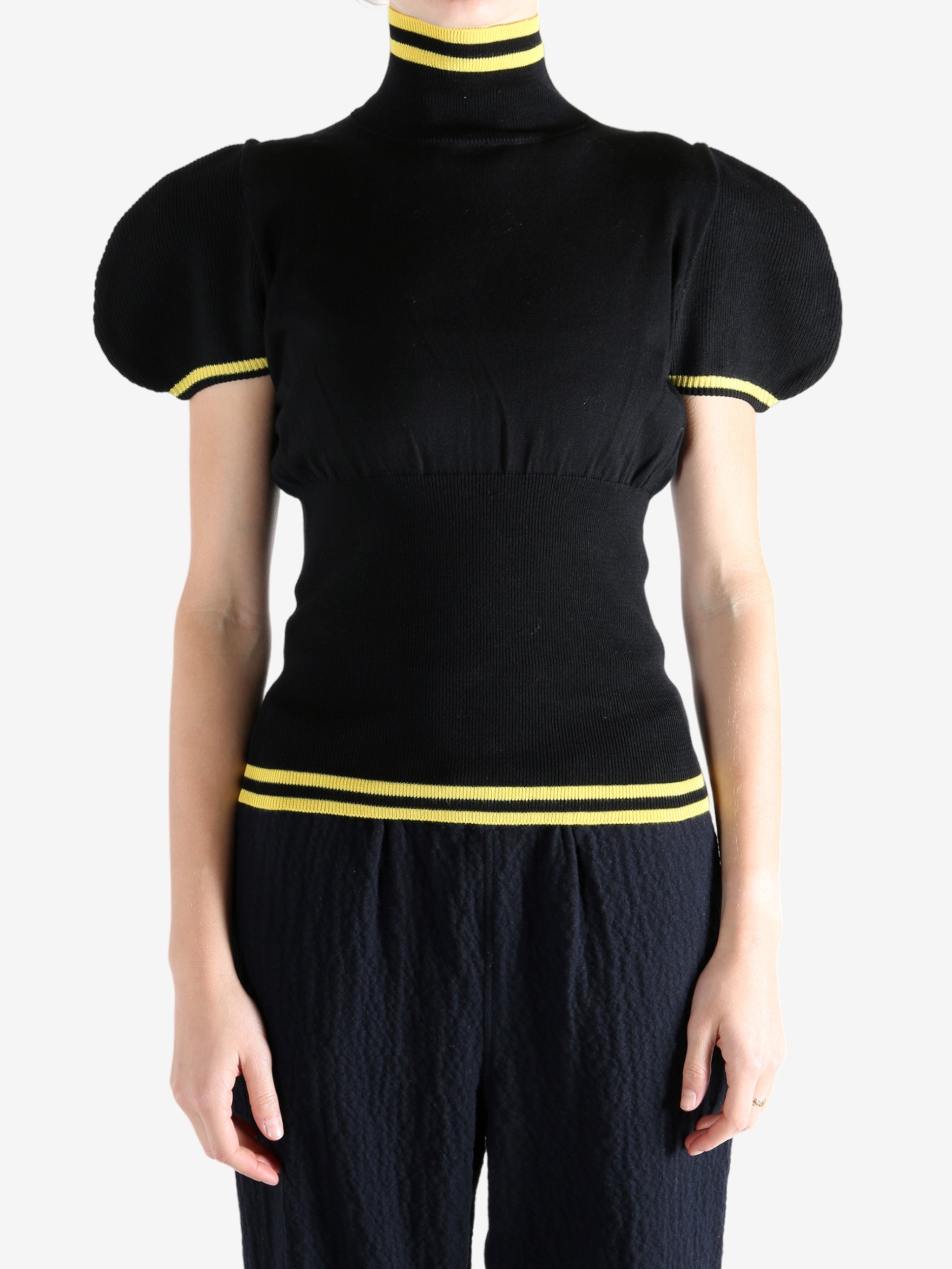 Black tops worn by a person, showing the top fit