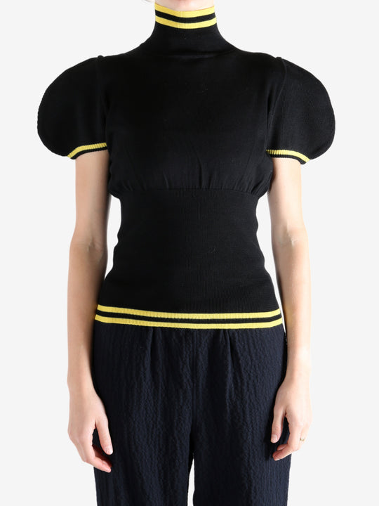 Black tops worn by a person, showing the top fit