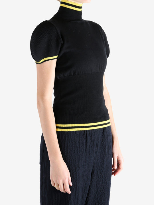 Black tops worn by a person, showing the top fit