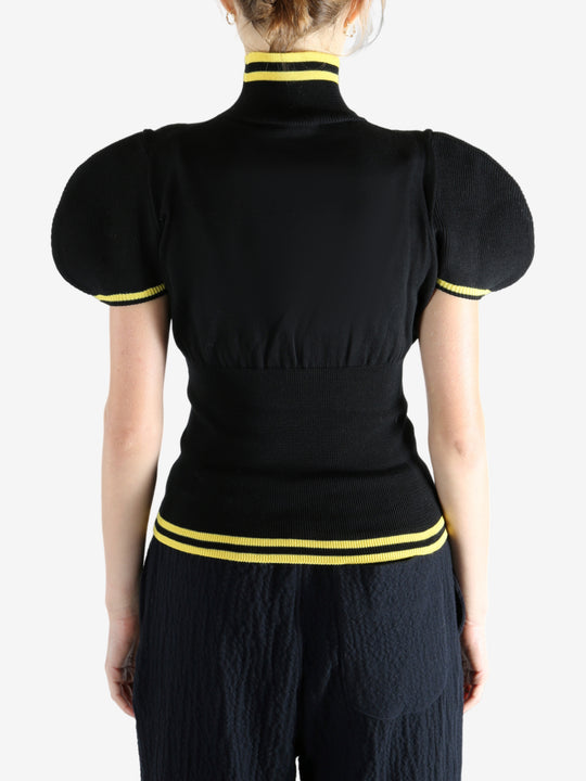 Black tops worn by a person, showing the top fit