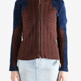 Burgundy knitwear worn by a person, showing the knitwear's fit