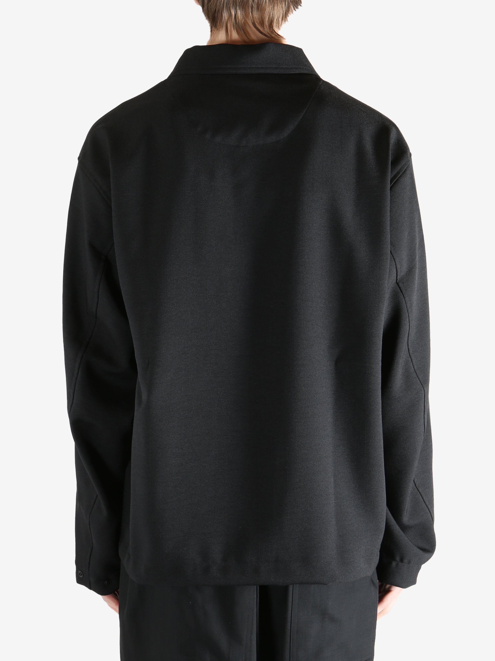 Black jacket worn by a person, showing the jacket fit