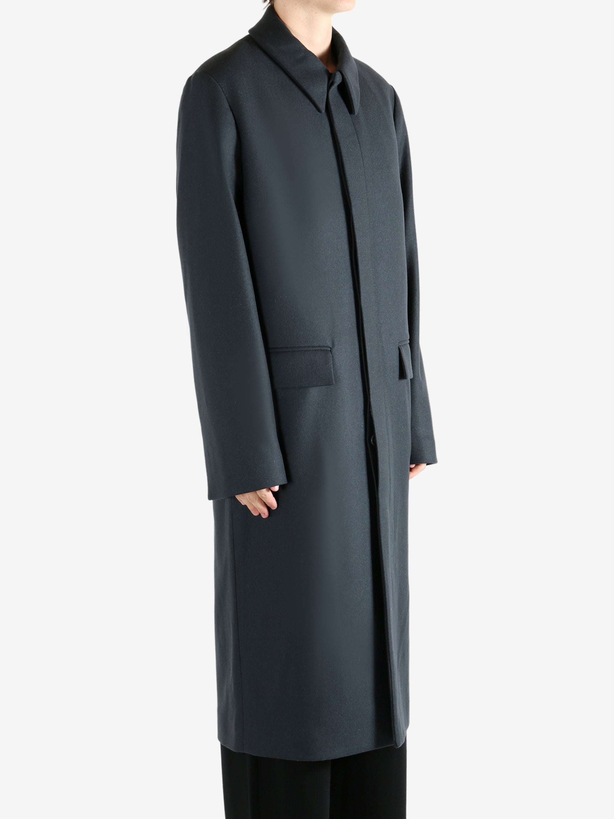 Black coat, worn by a person, showing the coat's fit