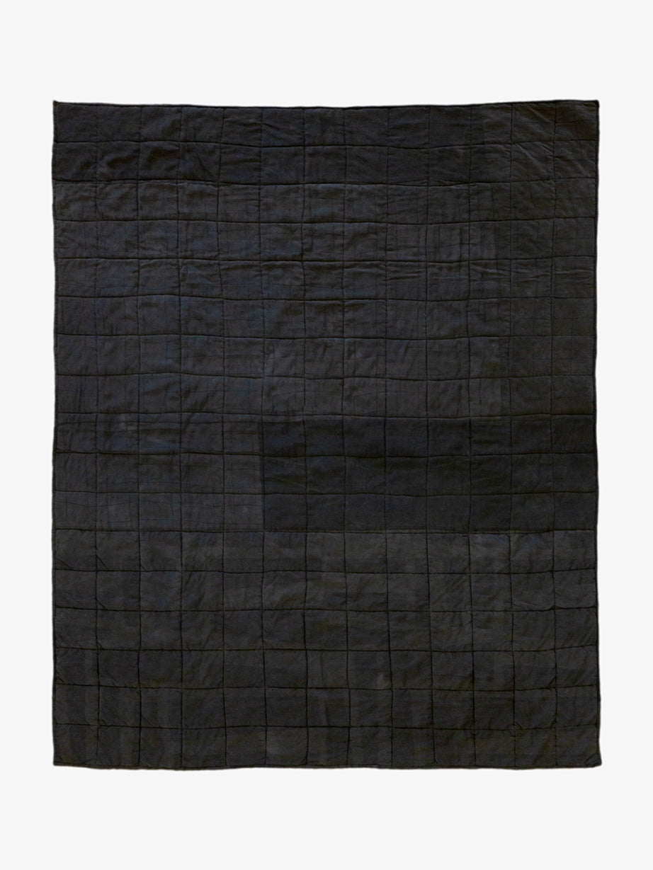 Back view of Lily Raskind Granny Square quilt, showing solid black patchwork backing and hand-stitched construction.