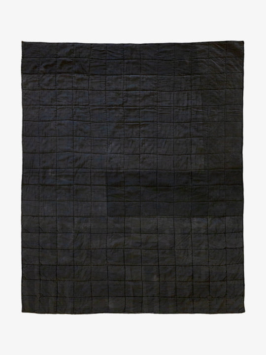 Back view of Lily Raskind Granny Square quilt, showing solid black patchwork backing and hand-stitched construction.