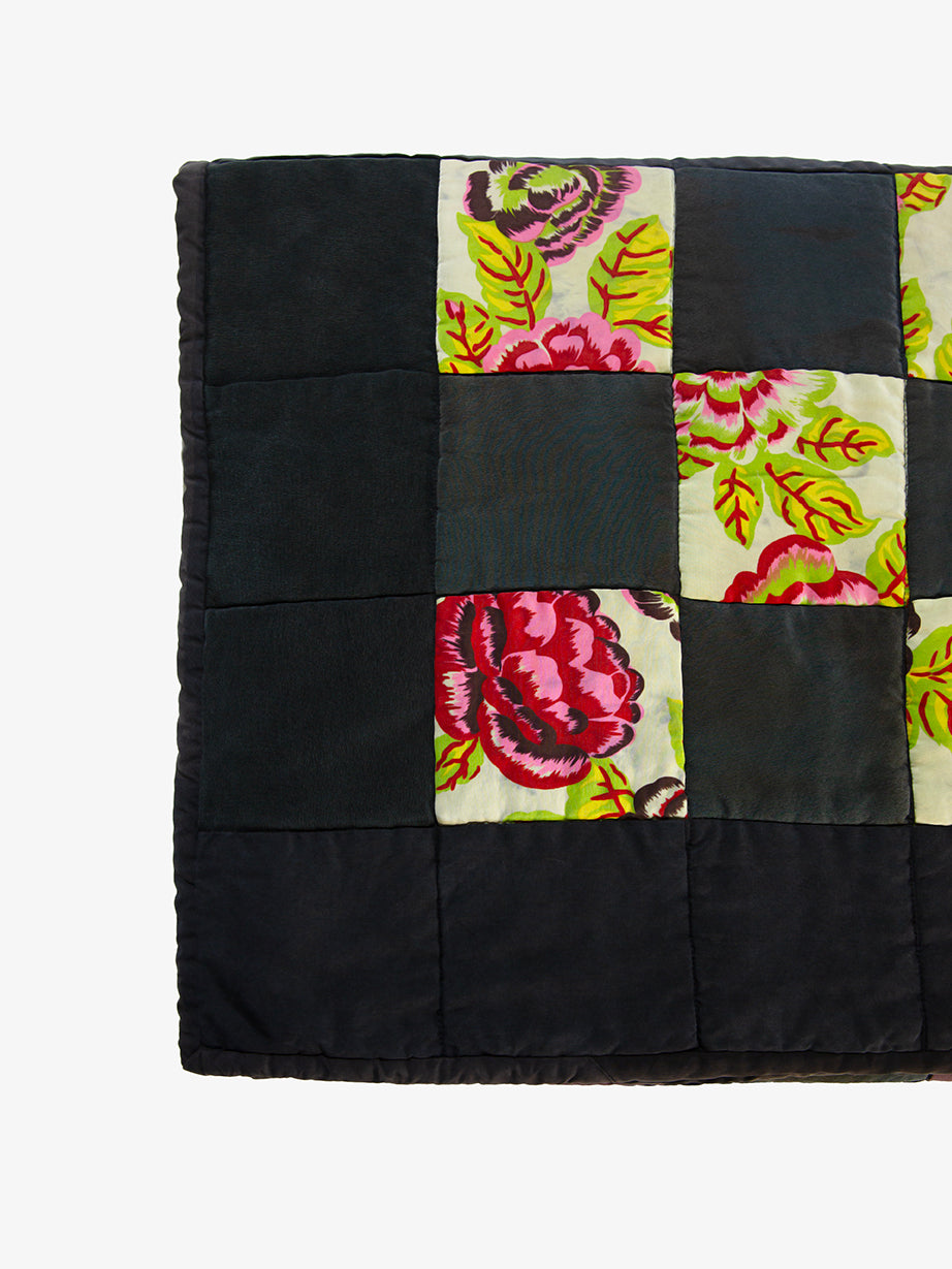 Floral patchwork detail on Lily Raskind quilt highlighting color, texture, and stitching.