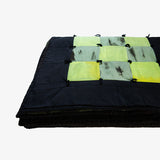 Folded view of Lily Raskind Granny Square quilt highlighting thickness and hand-dyed patchwork squares.