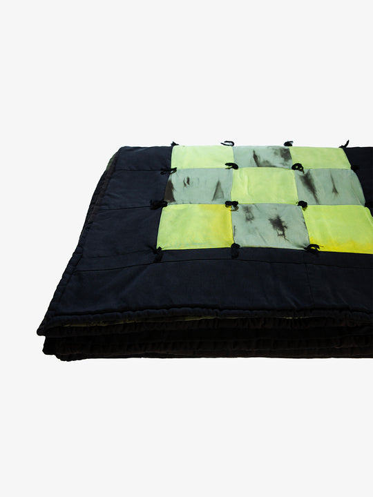 Folded view of Lily Raskind Granny Square quilt highlighting thickness and hand-dyed patchwork squares.