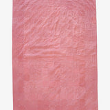 Hand-dyed dusty rose silk patchwork quilt by Lily Raskind, shown flat with square grid stitching detail.