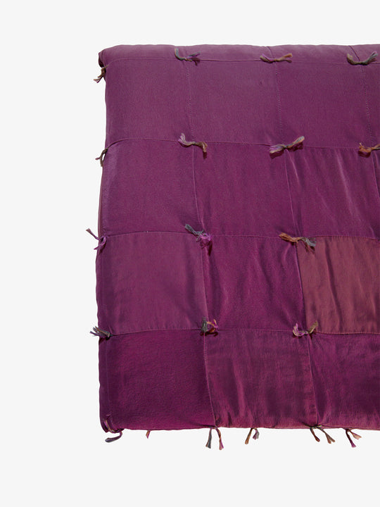 Close-up detail of Lily Raskind Smoke Brush hand-dyed silk blanket showing patchwork squares and hand-tied knots.