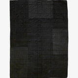 Back view of handmade silk patchwork quilt by Lily Raskind showing solid black stitched grid pattern