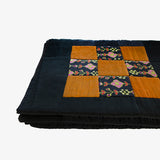 Silk patchwork quilt by Lily Raskind, folded to reveal padding and quilt thickness.