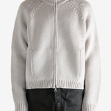 White cardigan worn by a person, showing the cardigan's fit