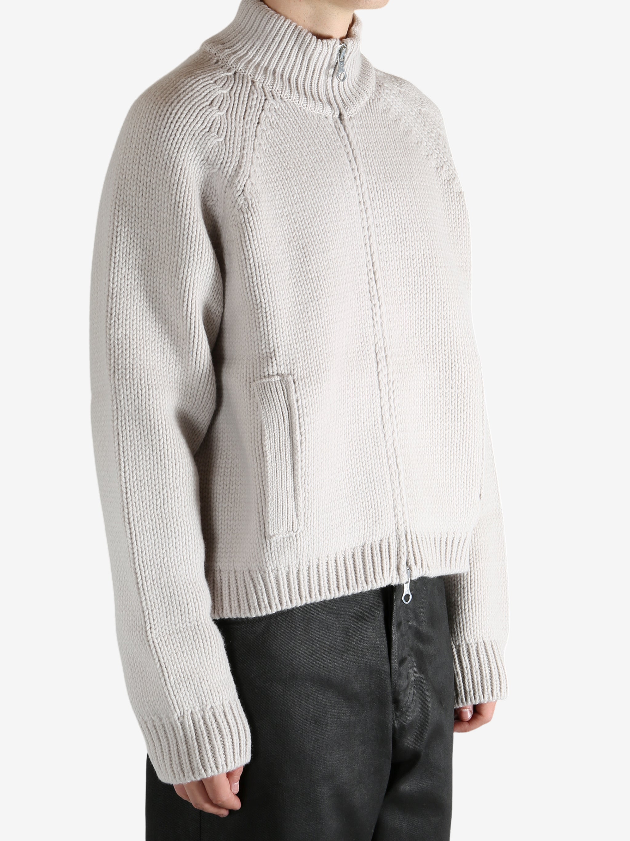 White cardigan worn by a person, showing the cardigan's fit