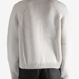 White cardigan worn by a person, showing the cardigan's fit