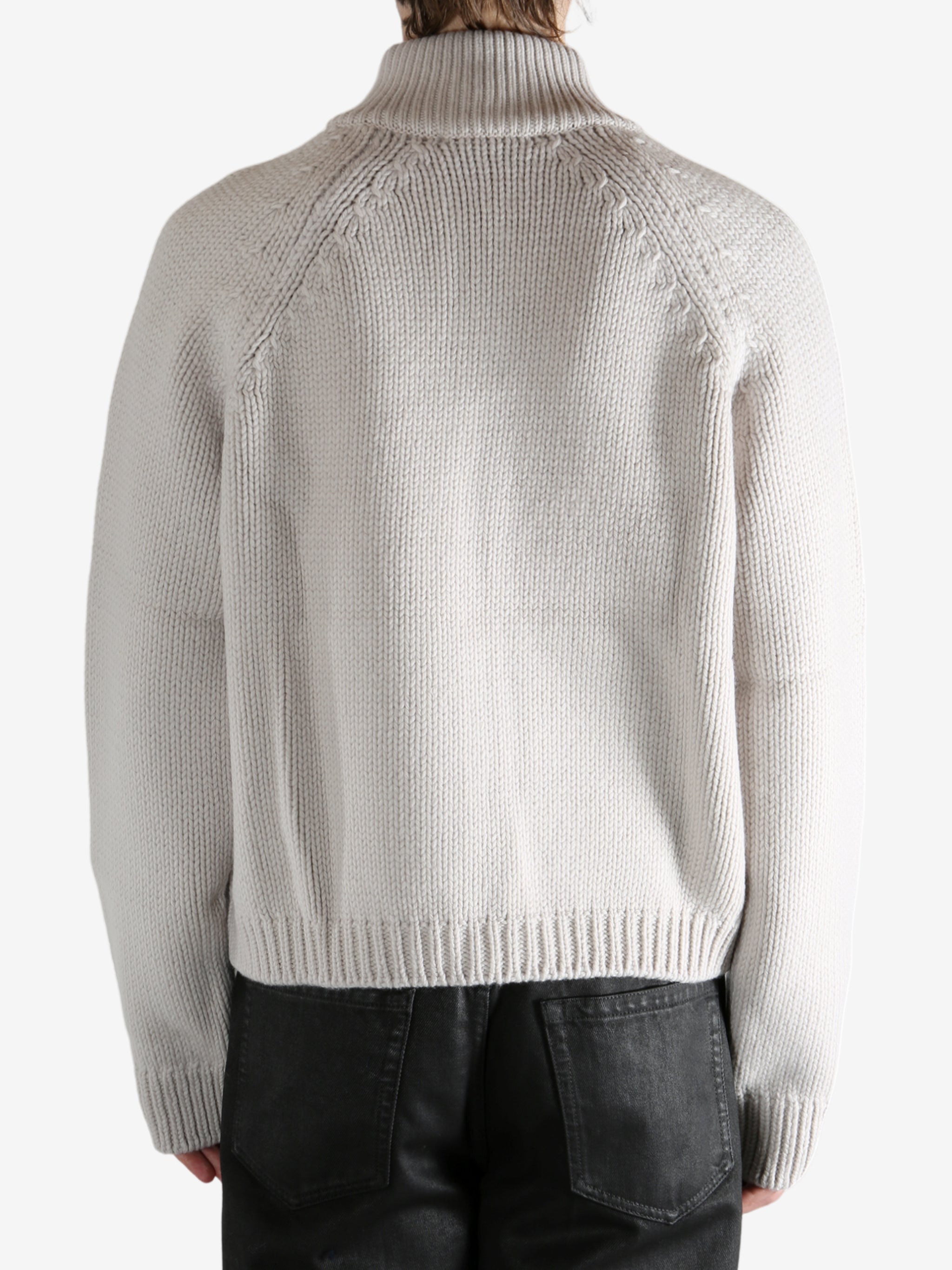 White cardigan worn by a person, showing the cardigan's fit