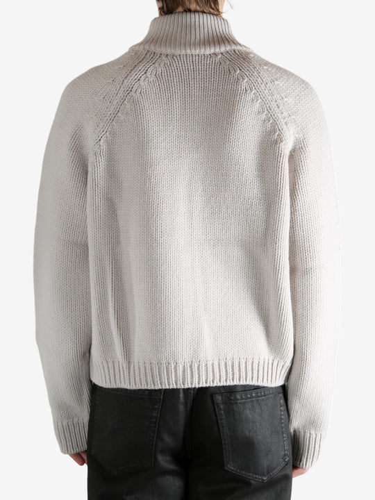 White cardigan worn by a person, showing the cardigan's fit