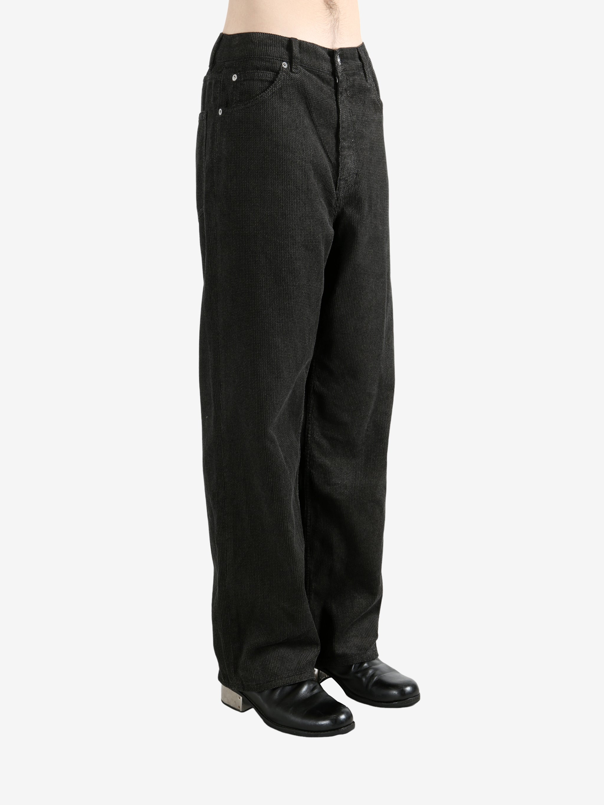 Black pants worn by a person, showing the pants's fit