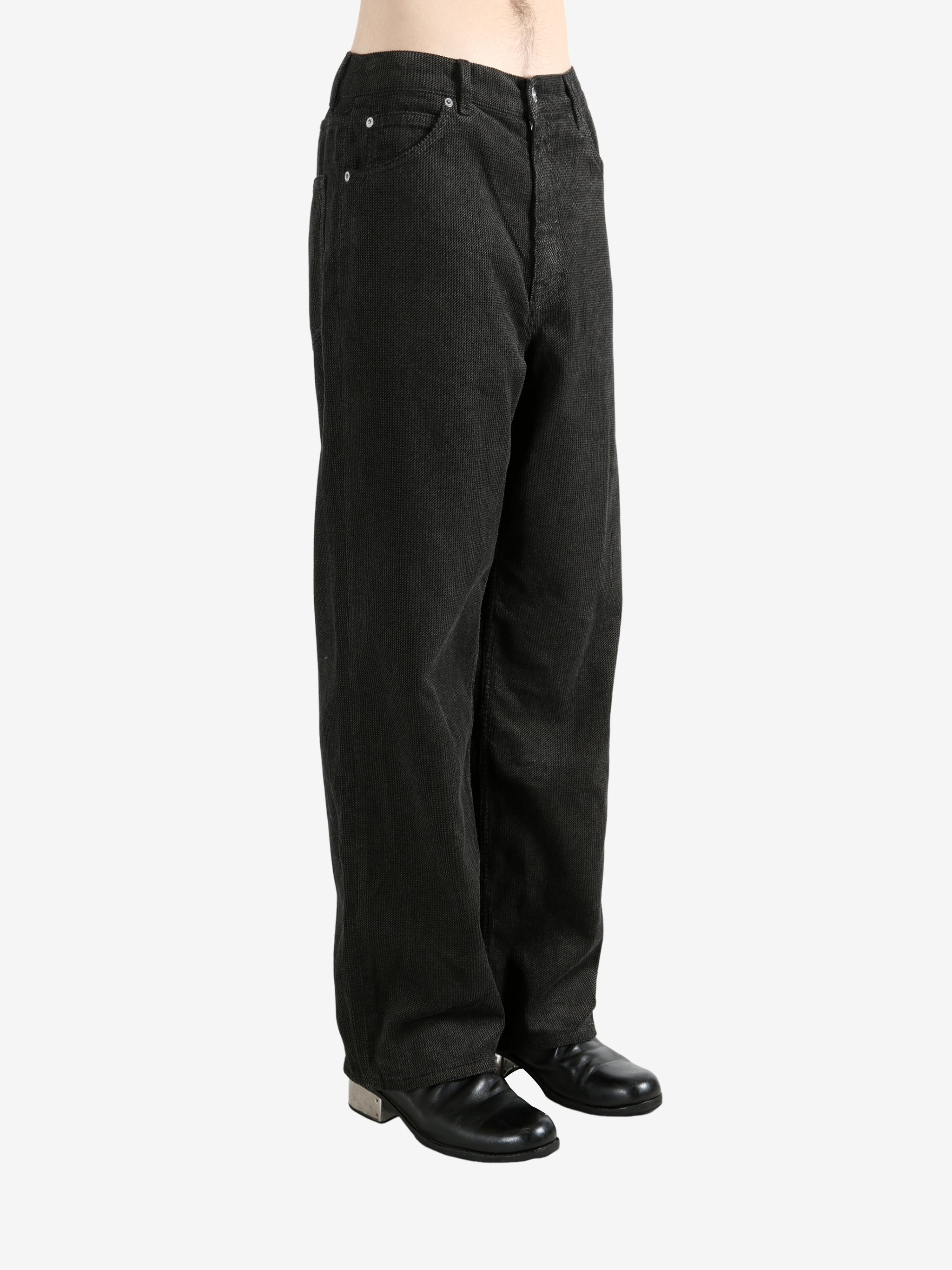 Black pants worn by a person, showing the pants's fit