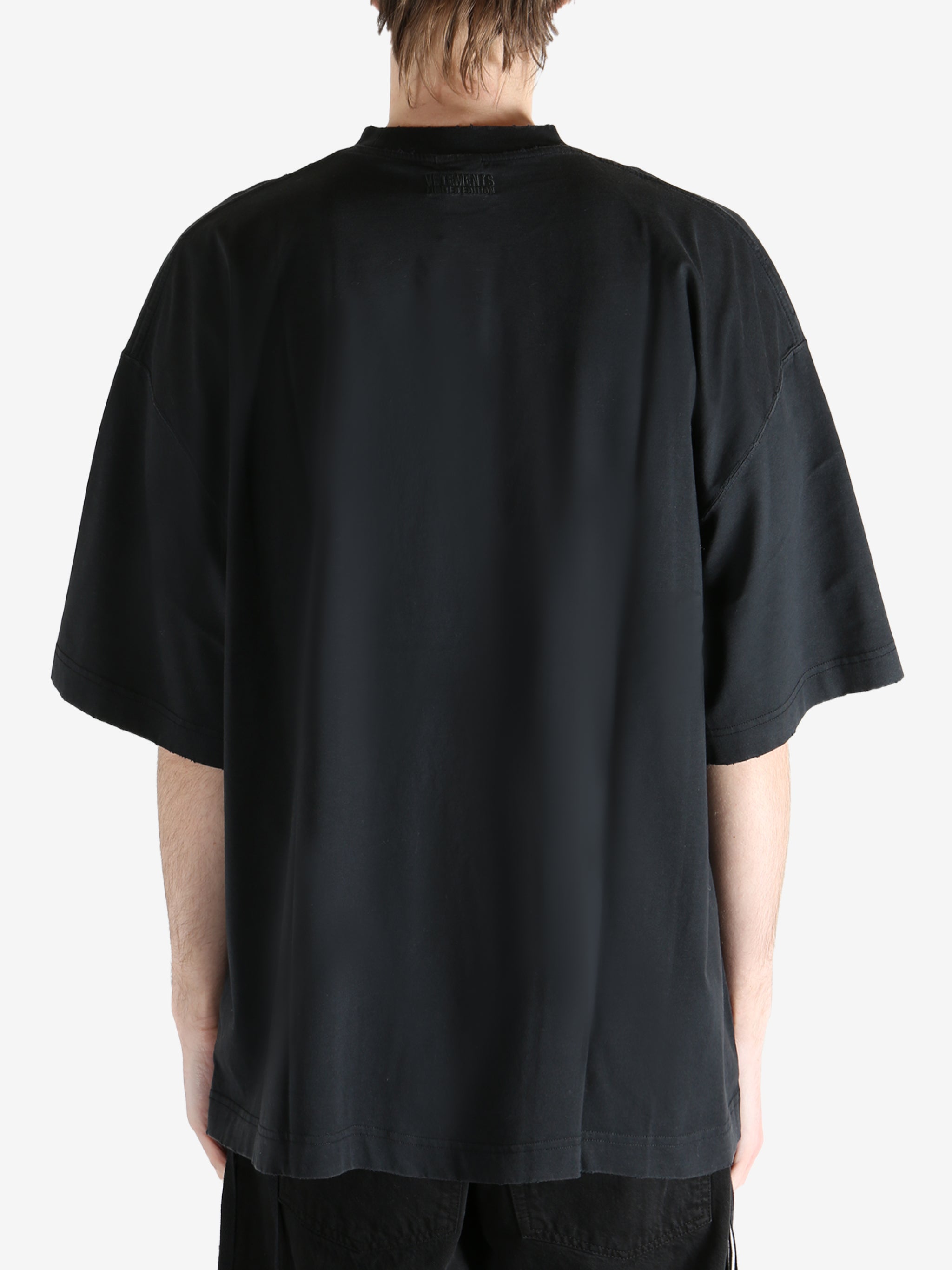 Black T-shirt worn by a person, showing the shirt fit