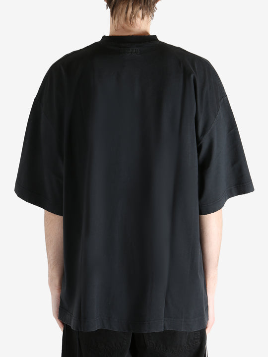 Black T-shirt worn by a person, showing the shirt fit