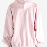 Pink hoodie worn by a person, showing the hoodie fit