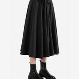 Black skirt worn by a person, side view