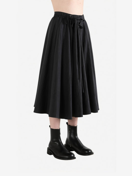 Black skirt worn by a person, side view