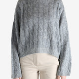 Grey sweater worn by a person, showing the sweater's fit