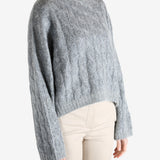 Grey sweater worn by a person, showing the sweater's fit