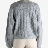 Grey sweater worn by a person, showing the sweater's fit
