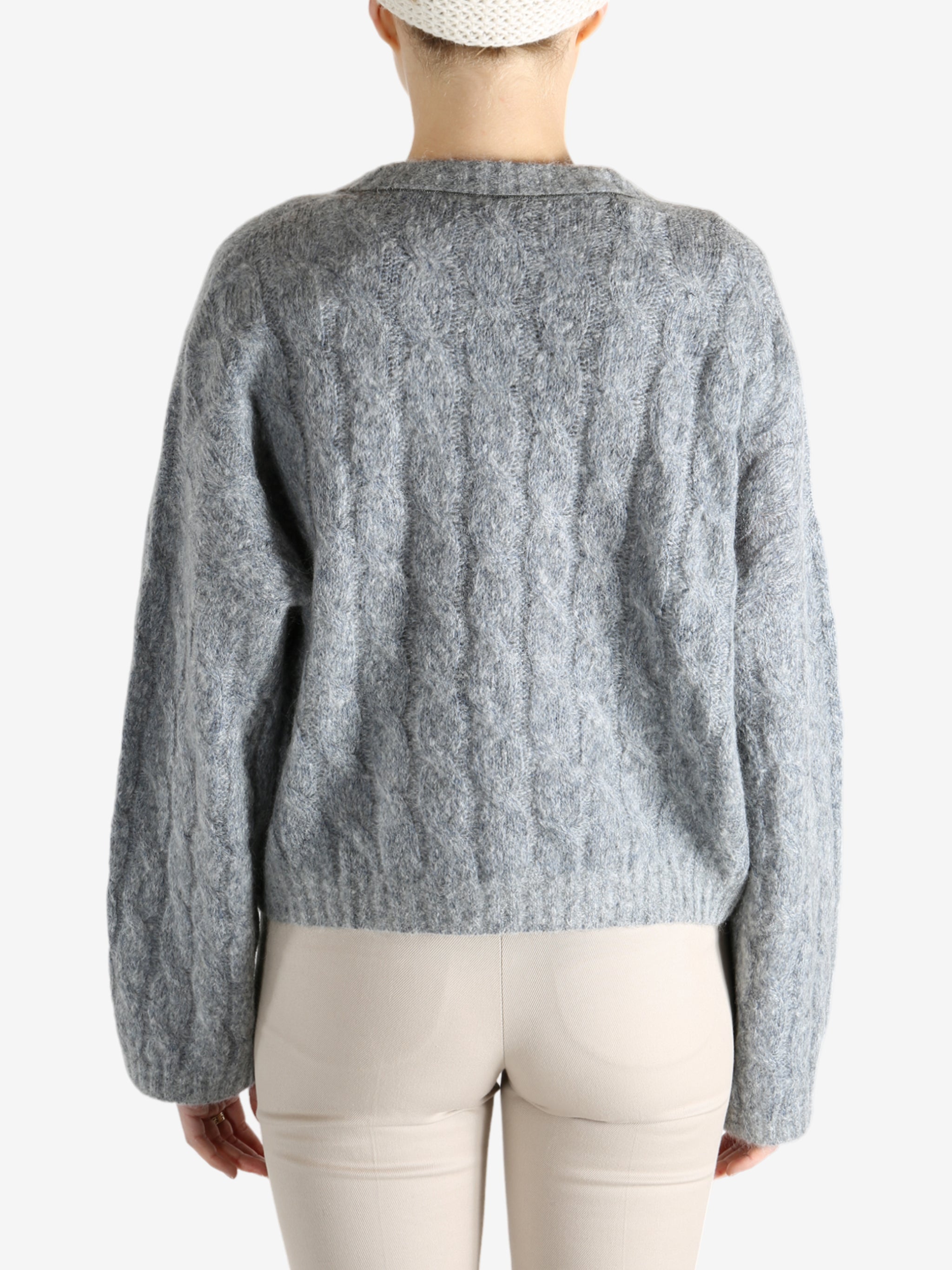 Grey sweater worn by a person, showing the sweater's fit