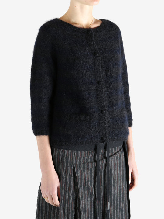 Black cardigan worn by a person, showing the cardigan's fit