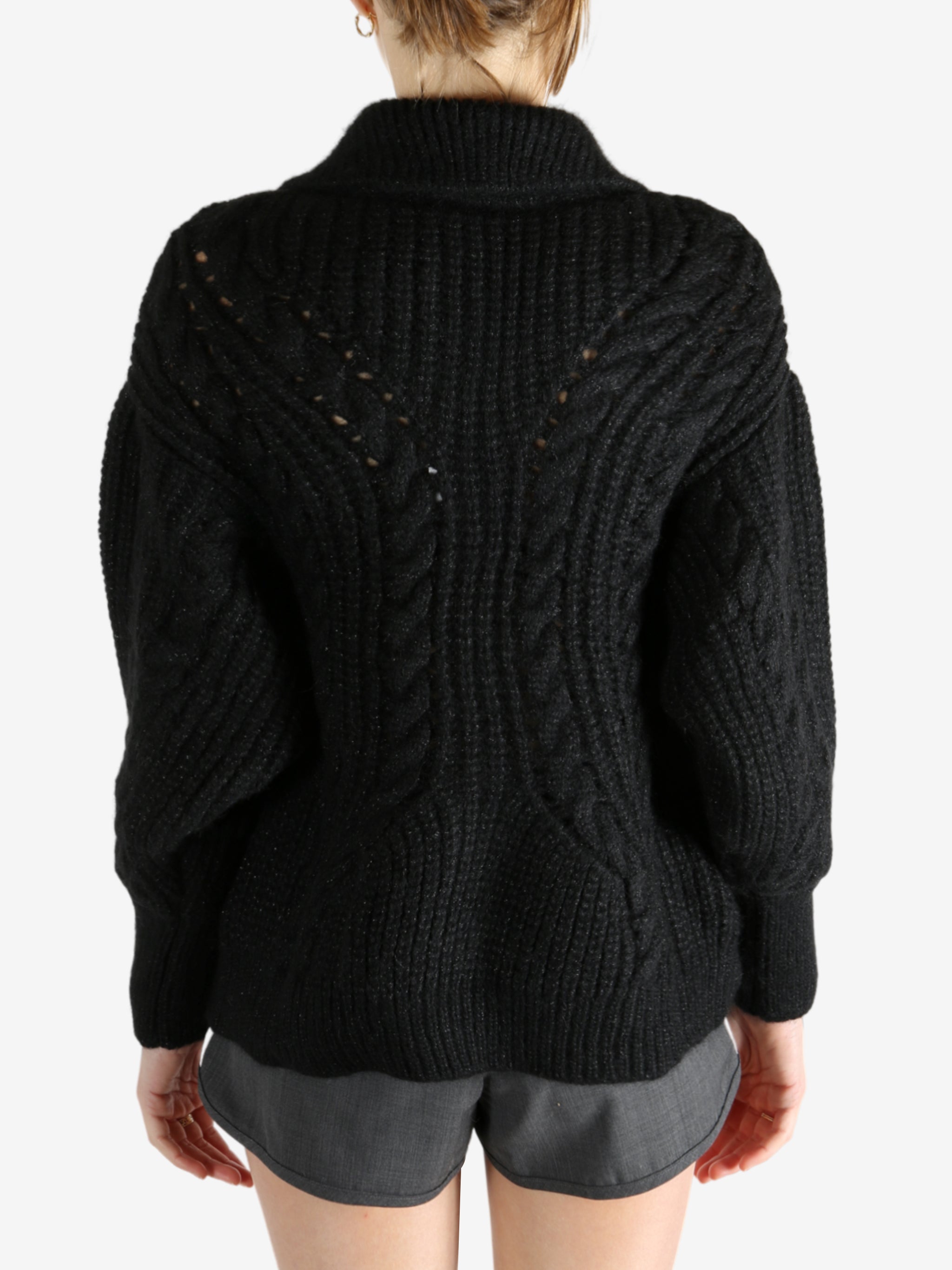Black knitwear worn by a person, showing the knitwear fit