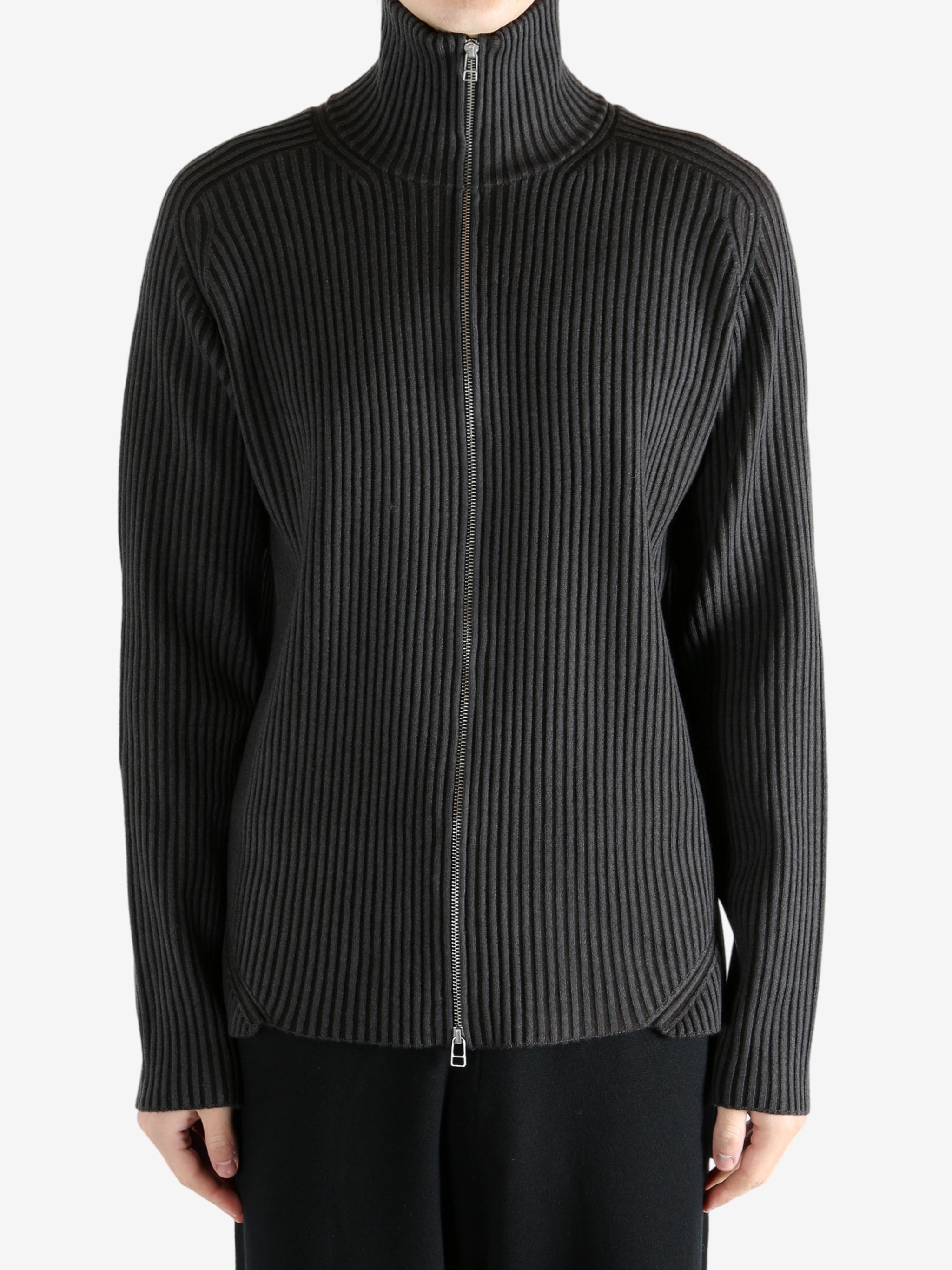 Black knitwear worn by a person, showing the knitwear's fit