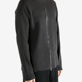 Black knitwear worn by a person, showing the knitwear's fit